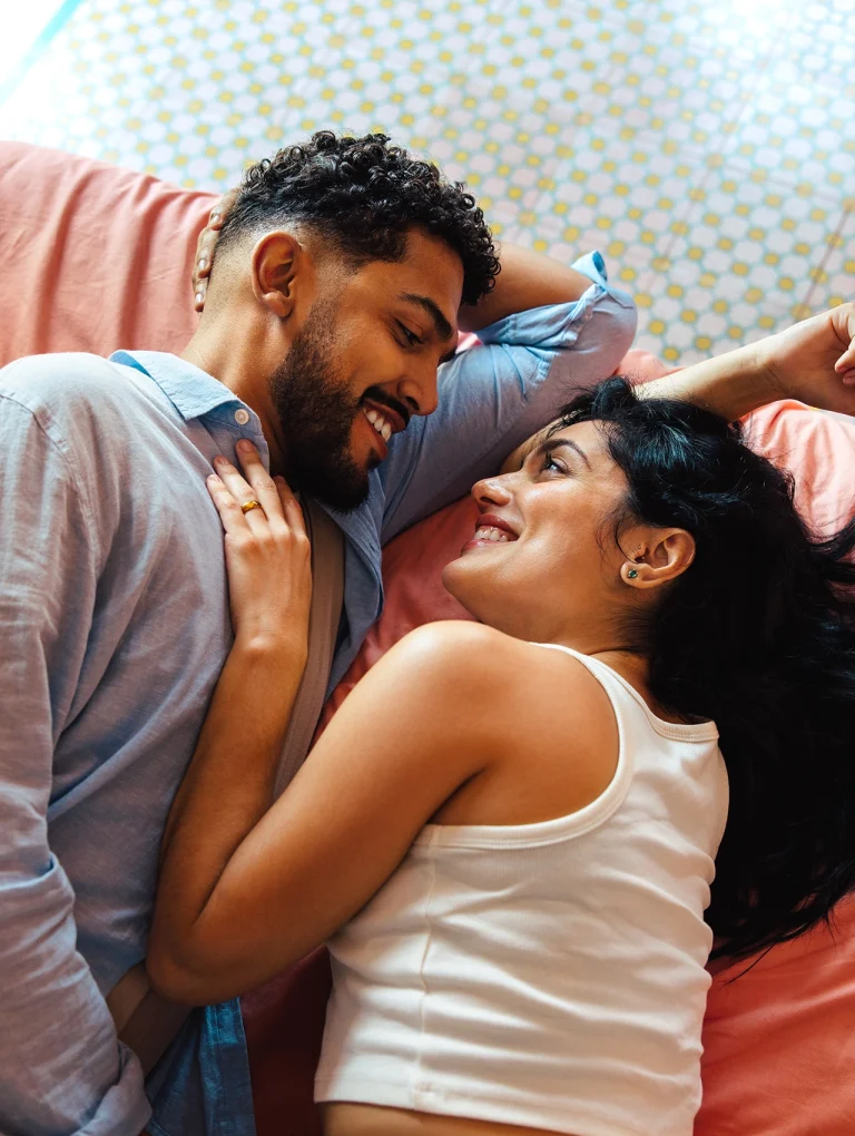 Pareja recostada mirándose con afecto mostrando cómo recuperar la confianza en tu pareja.