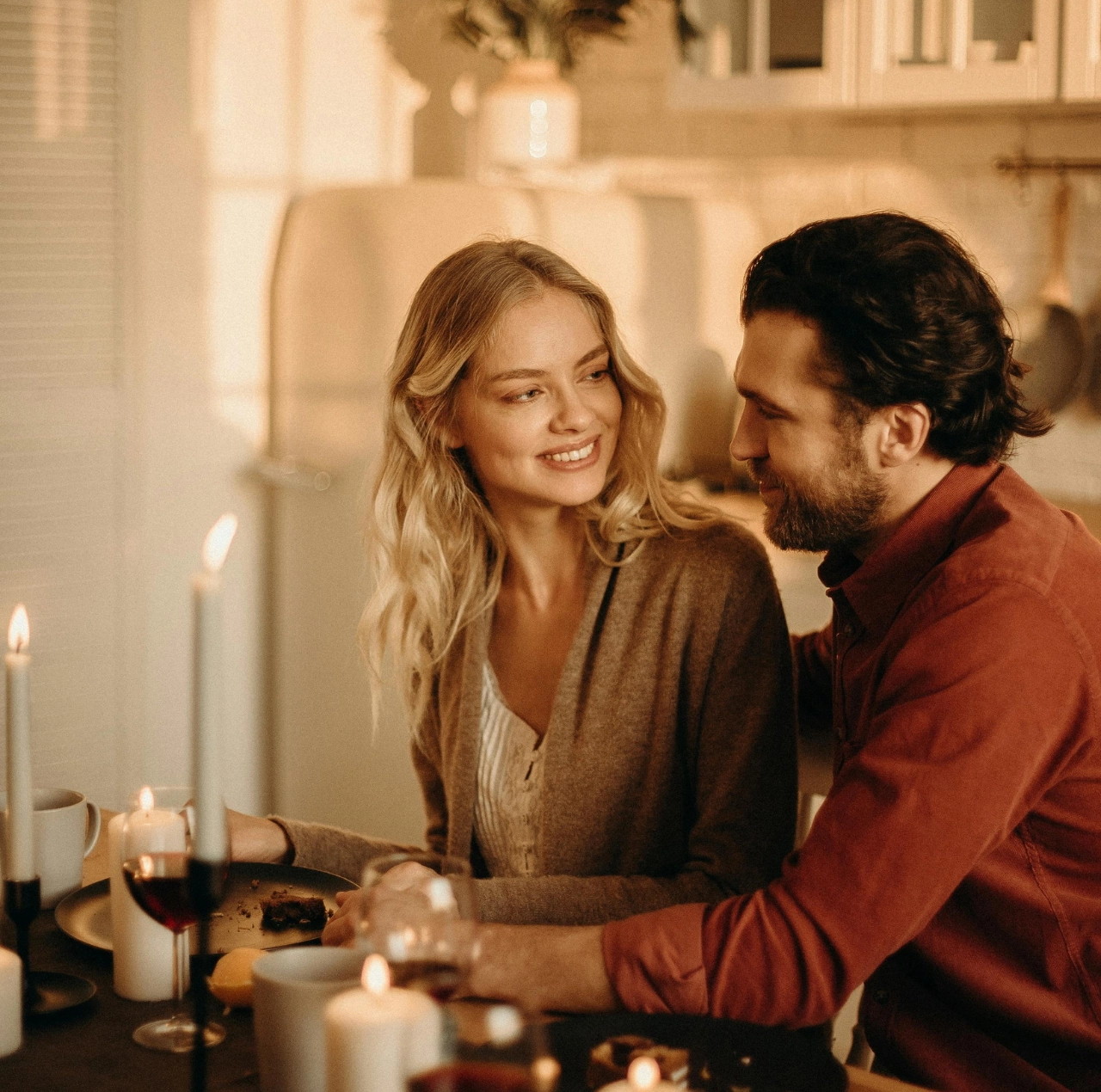 Pareja sonriente en una cena romántica representando la duda sobre si es amor o encaprichamiento.