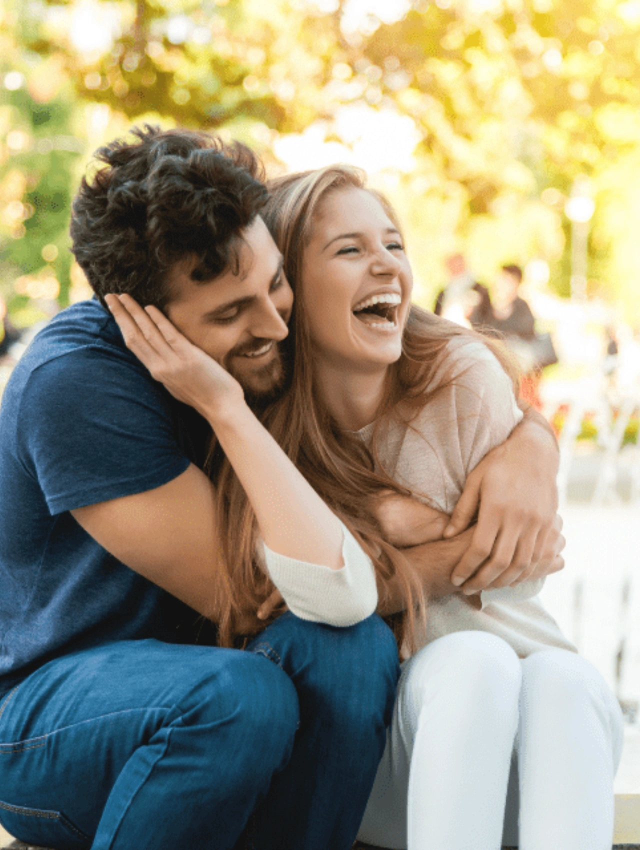 Pareja abrazándose en un parque, título: Prevenir la infidelidad en las relaciones, con contacto físico positivo.