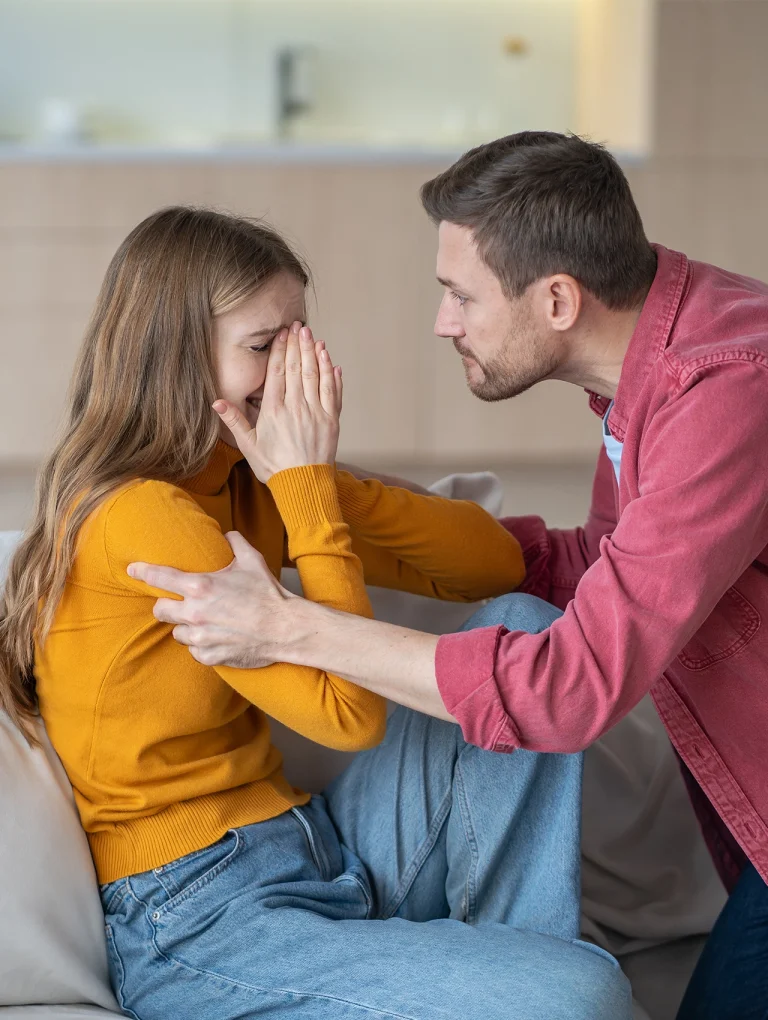 Hombre agarrando fuertemente a una mujer que llora y se cubre el rostro, representando una relación tóxica y agresiva.