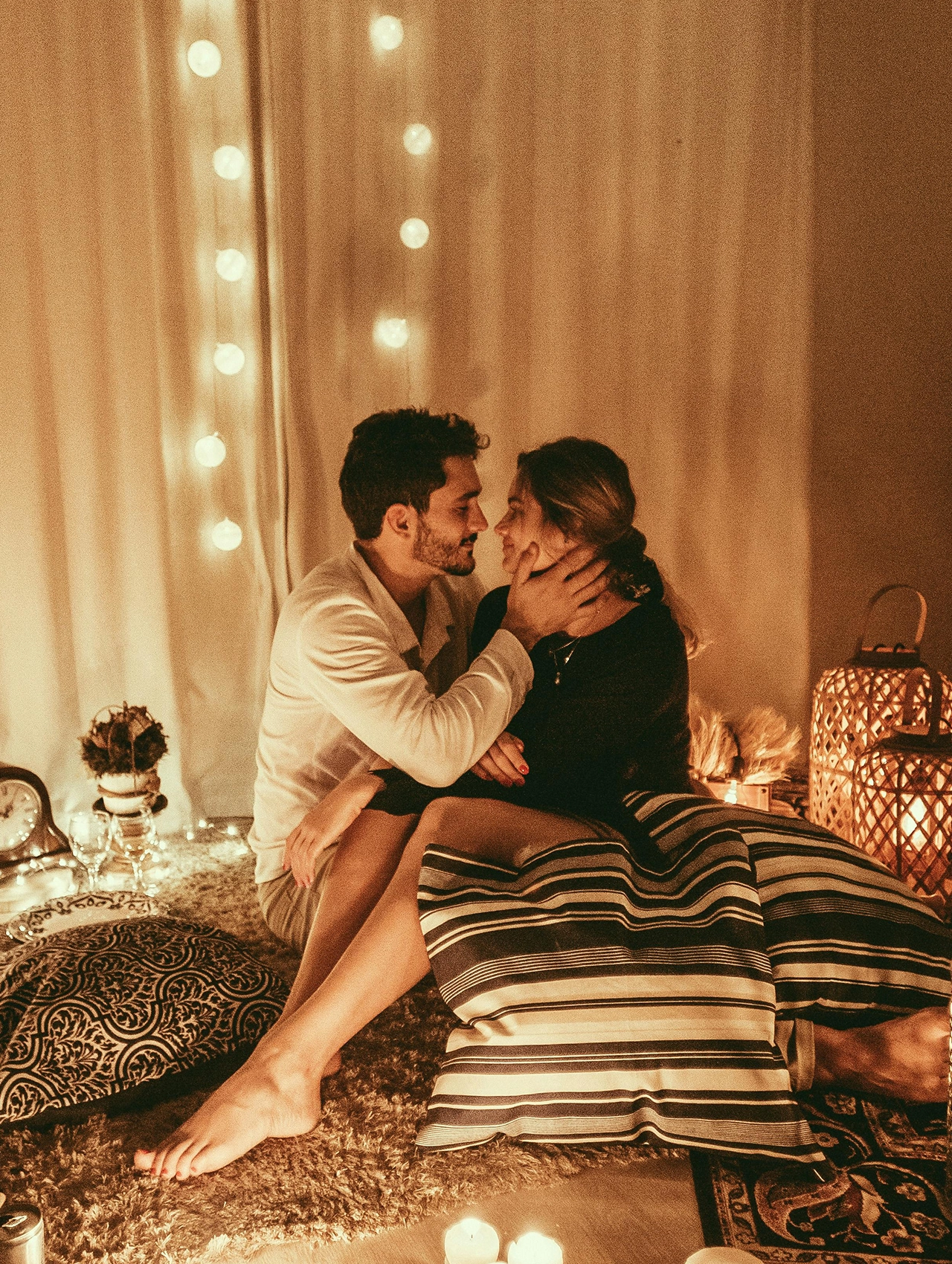 Pareja en una velada romántica con velas representando cuáles son los lenguajes del amor.
