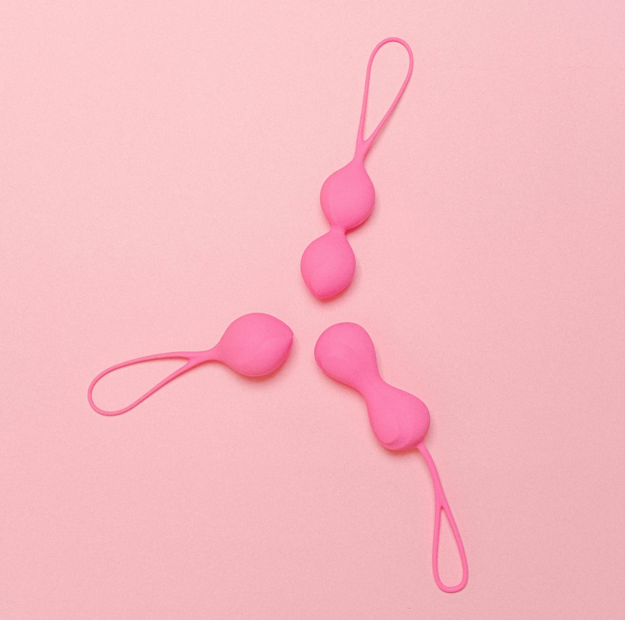 bolas chinas rosas sobre fondo rosa claro con el tema explora con juguetes en el contexto de bienestar sexual