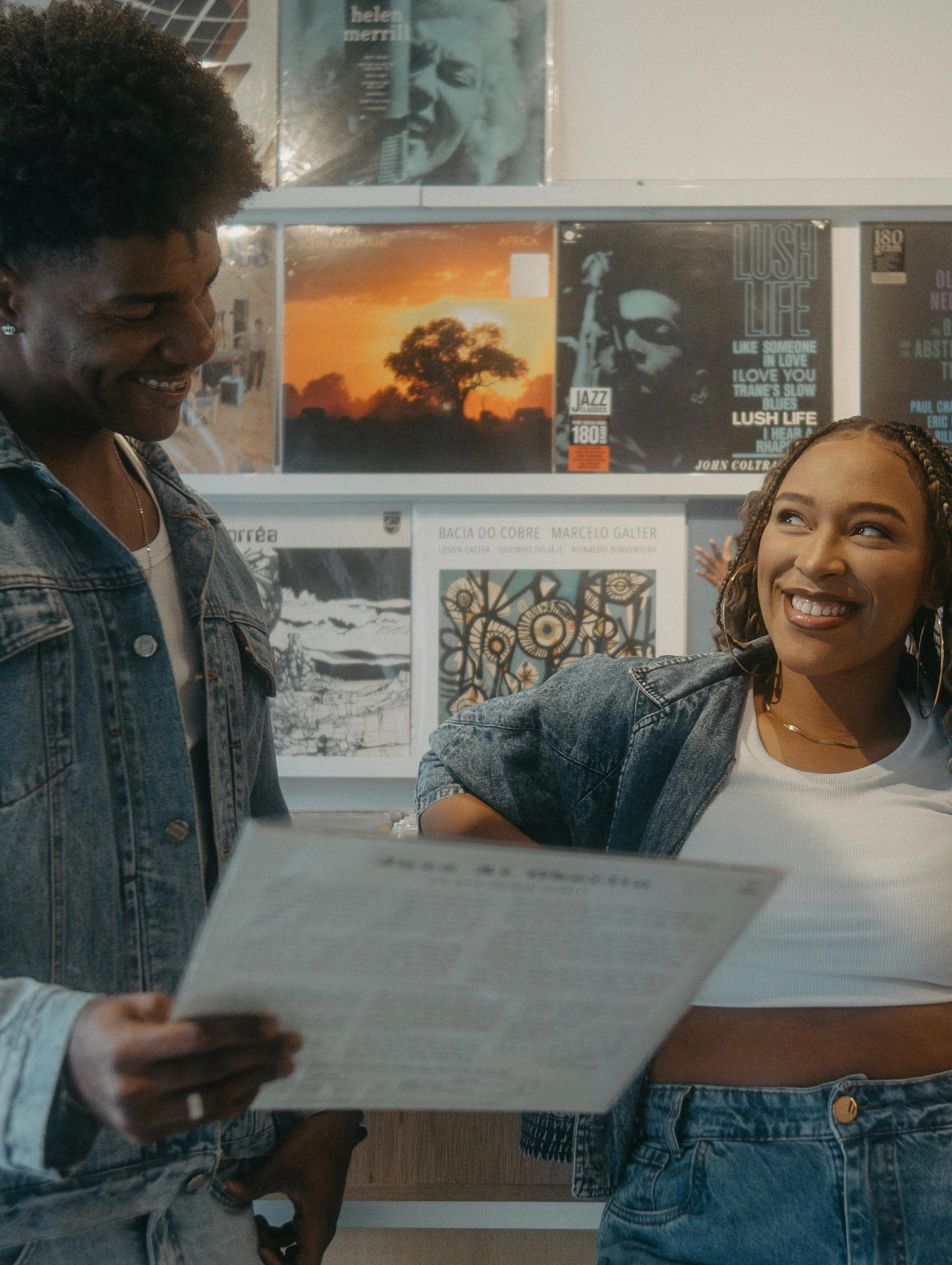 Pareja joven sonriendo en una tienda de discos, ideal para ilustrar "cómo saber si un hombre está enamorado
