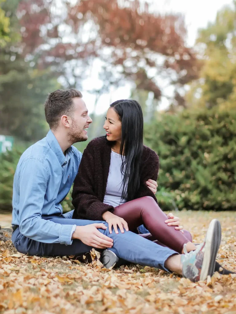 Pareja sentada en el parque en otoño mirándose a los ojos — cómo mejorar la comunicación en pareja