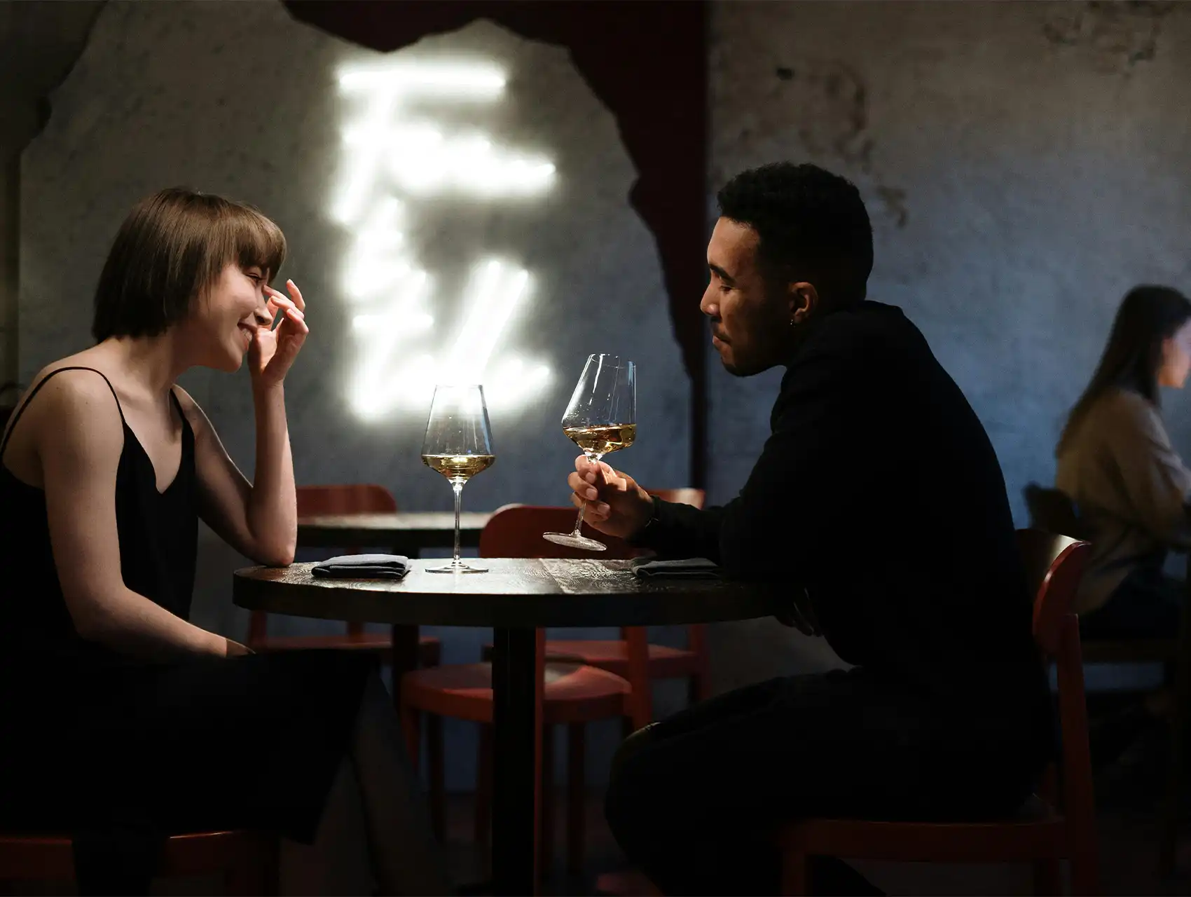 Pareja cenando con vino en un restaurante, en conversación íntima — cómo mejorar la comunicación en pareja