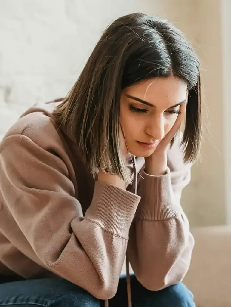 Mujer joven preocupada con sudadera rosa — consecuencias de tomar anticonceptivos por muchos años
