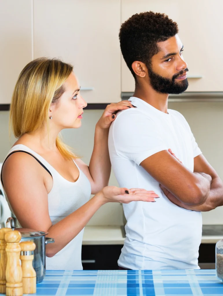 5 Consejos de psicólogos para parejas que están pasando por un mal momento, mujer intenta hablar con su pareja mientras él está serio con los brazos cruzados, consejos de psicólogos para parejas