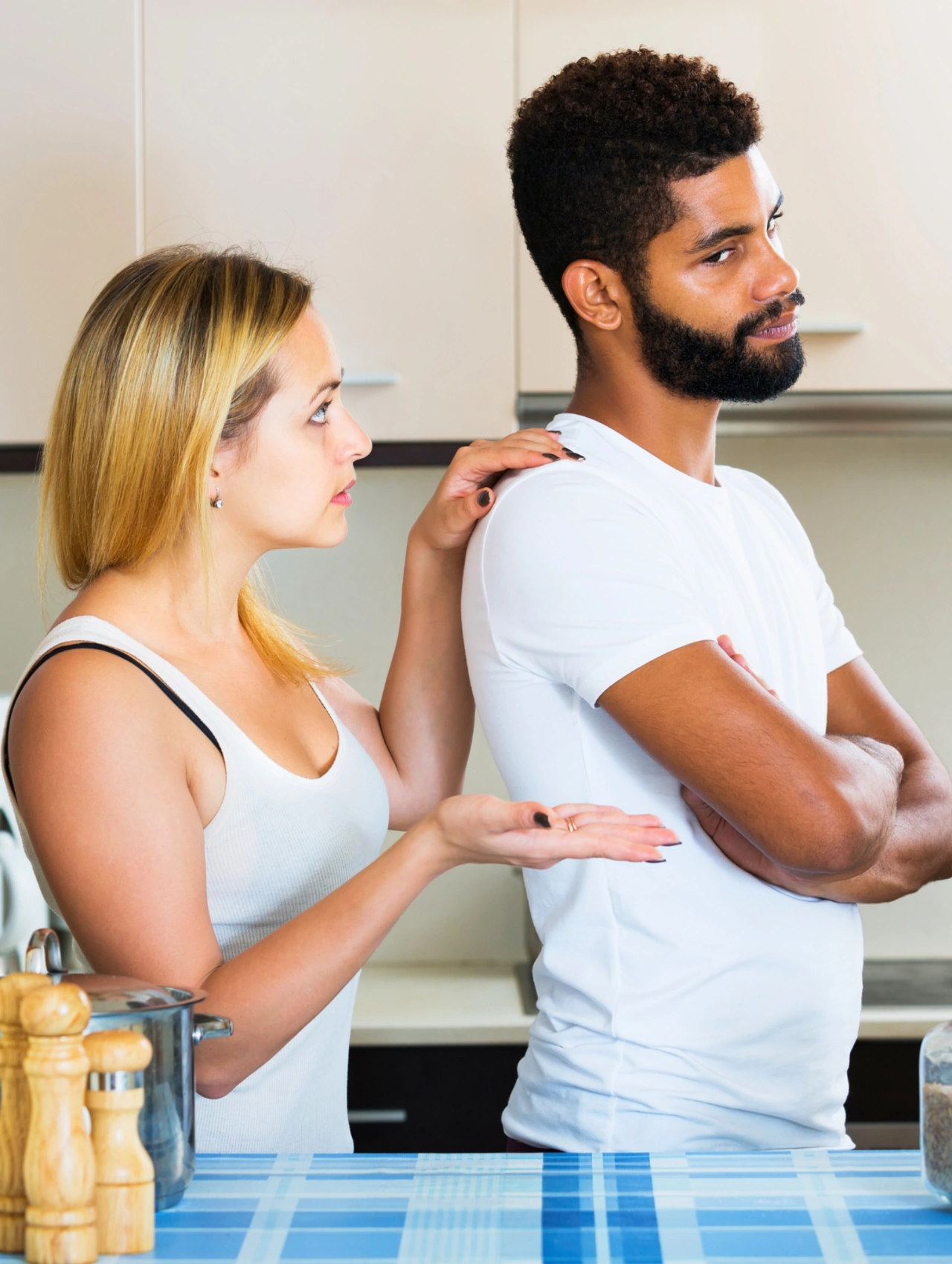 5 Consejos de psicólogos para parejas que están pasando por un mal momento, mujer intenta hablar con su pareja mientras él está serio con los brazos cruzados, consejos de psicólogos para parejas