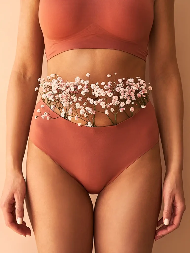 Calzones menstruales color terracota decorados con flores en el vientre bajo