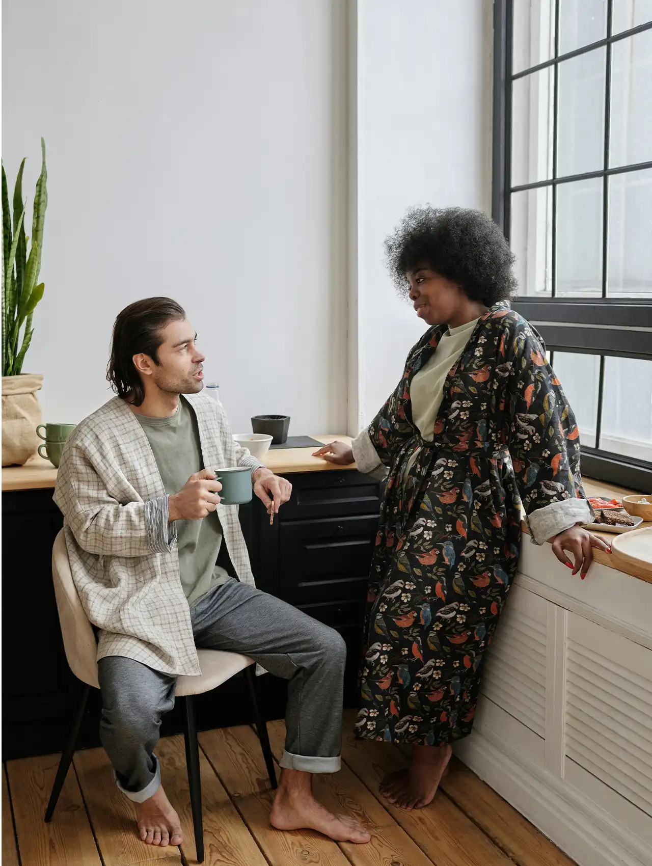 Pareja conversando tranquilamente en la cocina con batas cómodas – comunicación asertiva en pareja en casa