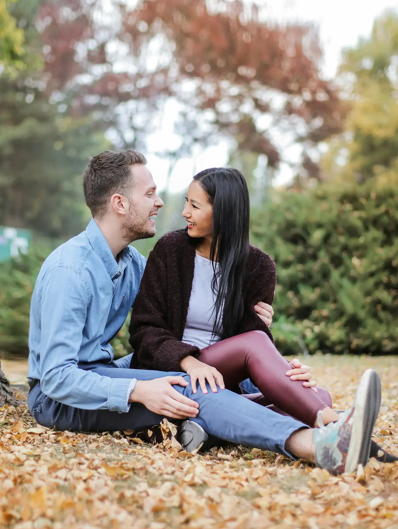 Pareja sentada en el parque sonriendo y conectando emocionalmente – comunicación asertiva en pareja