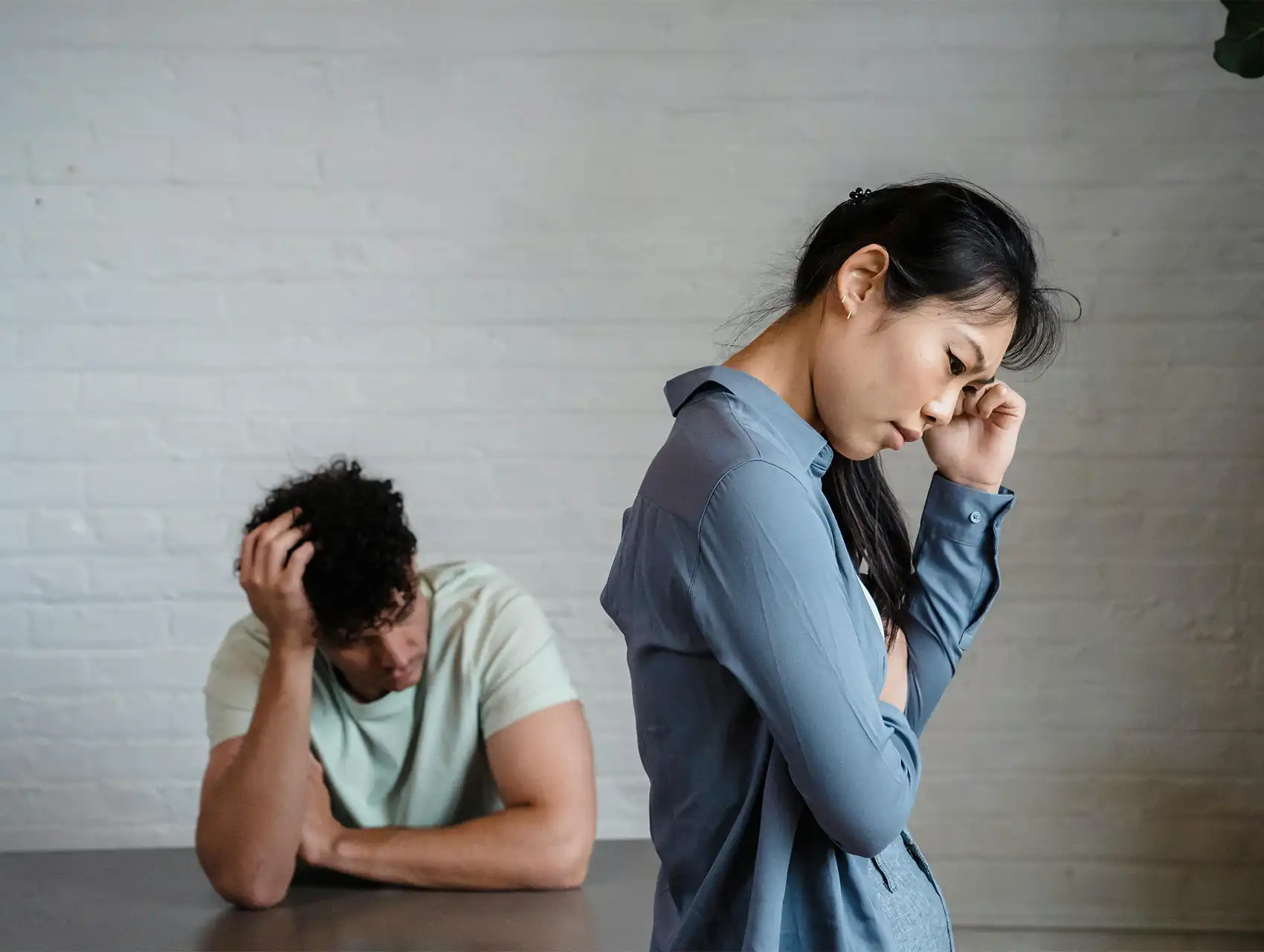 Pareja teniendo una fuerte discusión sentados en una sala – conflictos en pareja