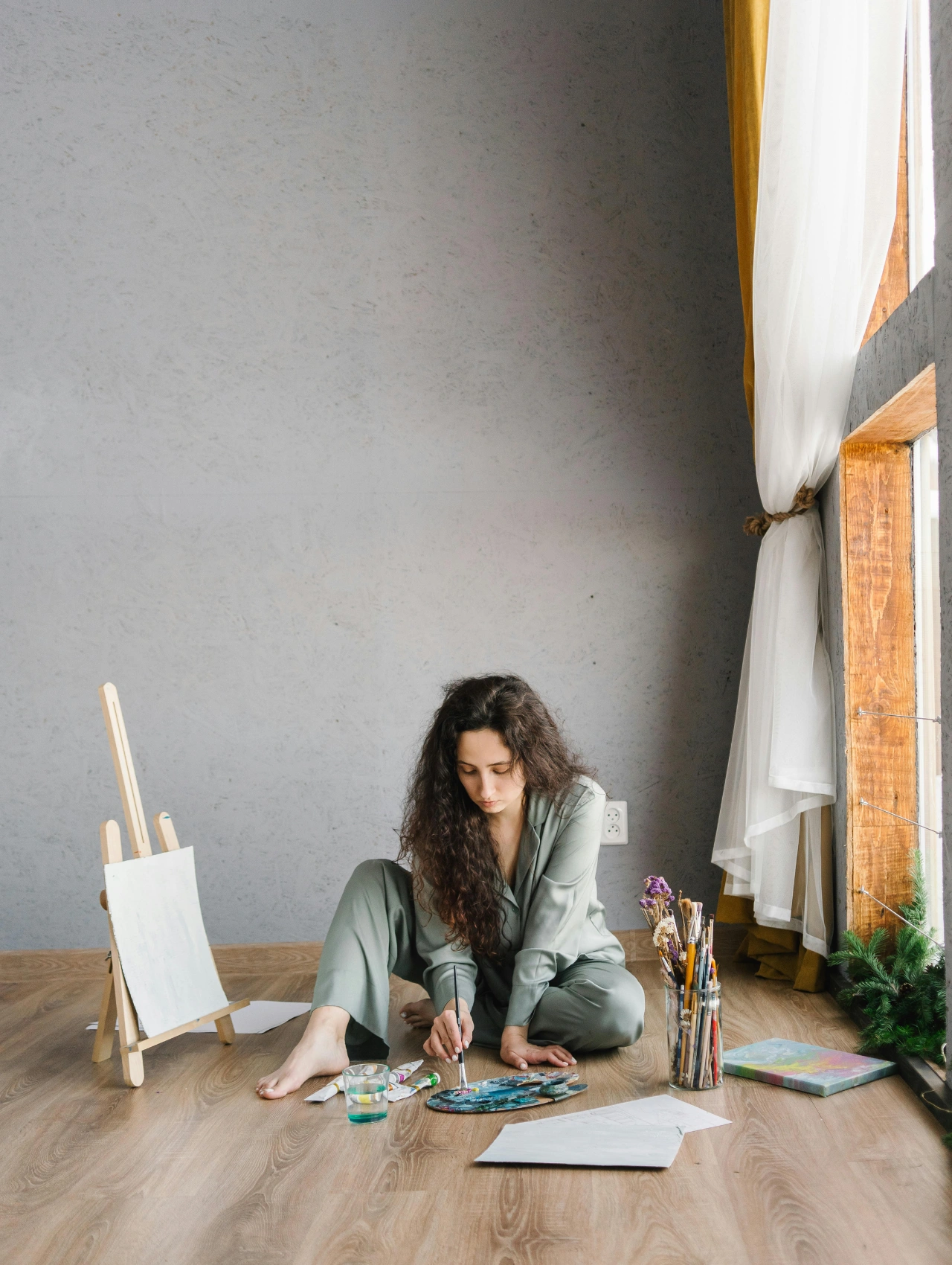 Mujer pintando en casa como forma de autocuidado tras una ruptura amorosa.
