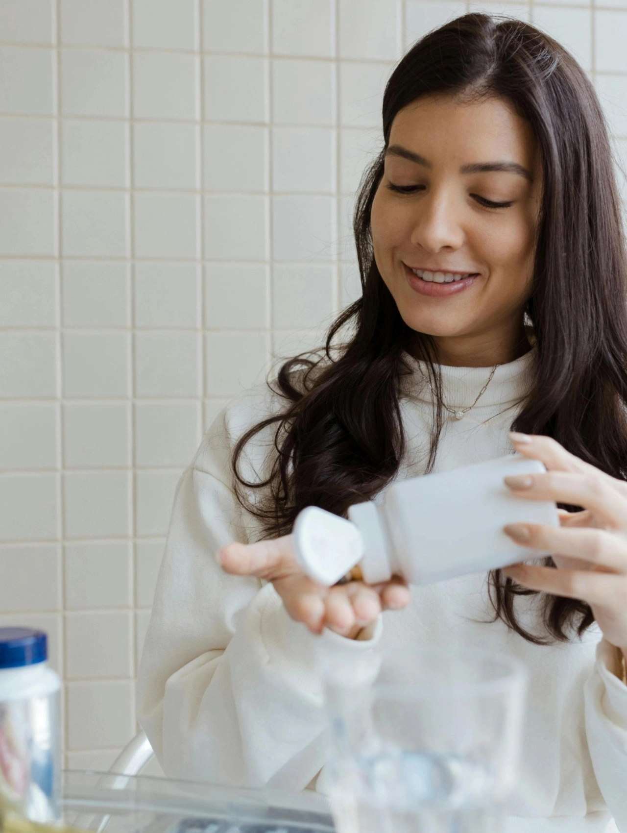 Mujer sonriente tomando suplemento, representando cambios de estilo de vida que complementan las vitaminas para aumentar el libido en la mujer.