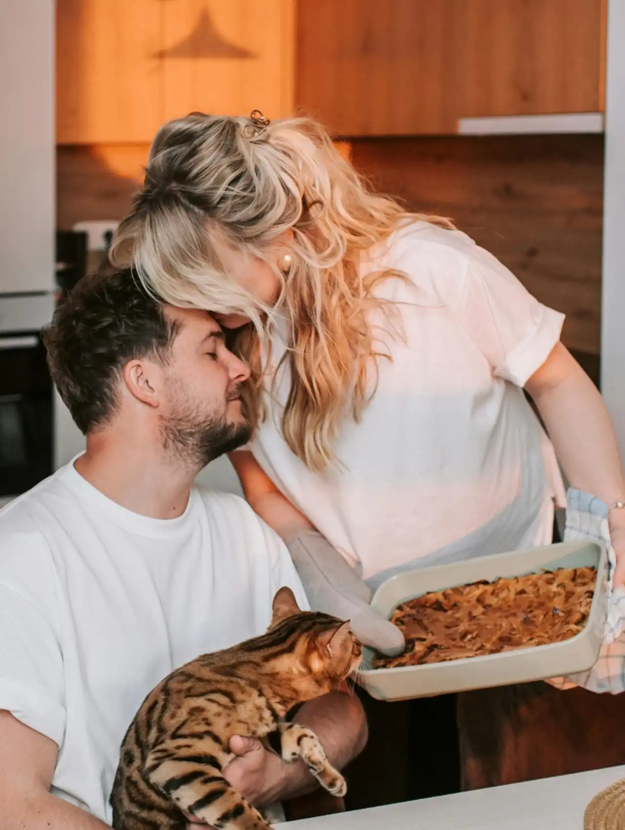 Pareja mostrando cariño en la cocina mientras comparten actos de servicio, cuáles son los lenguajes del amor.