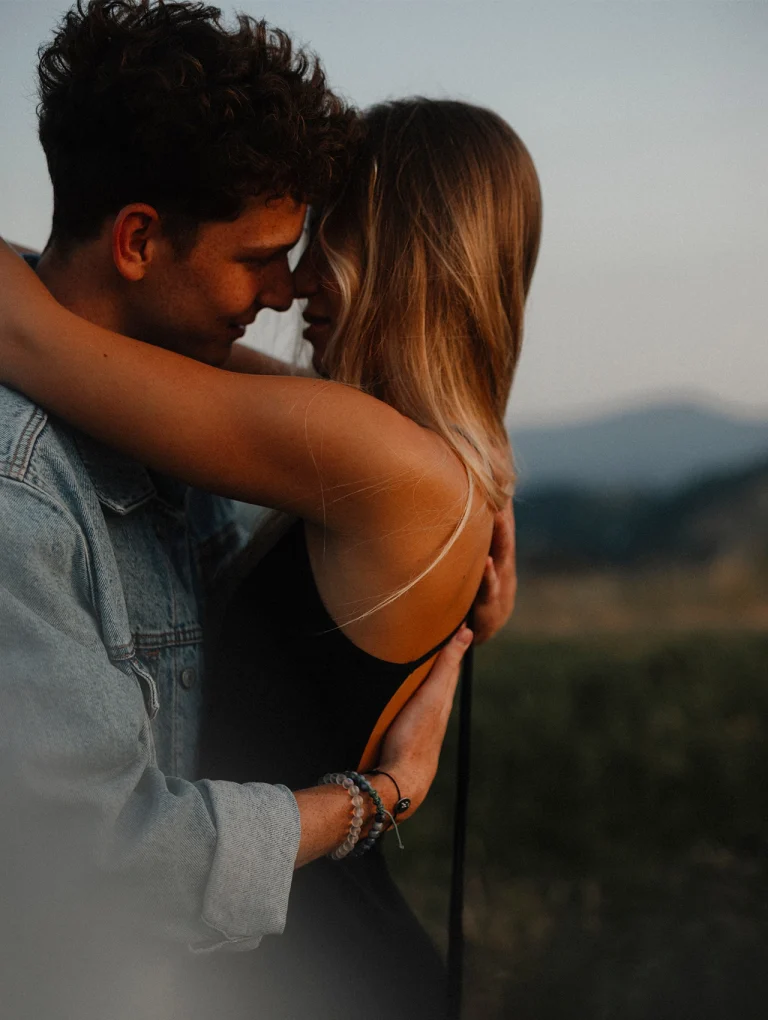 Pareja joven abrazándose al atardecer en un entorno natural – amor romántico.