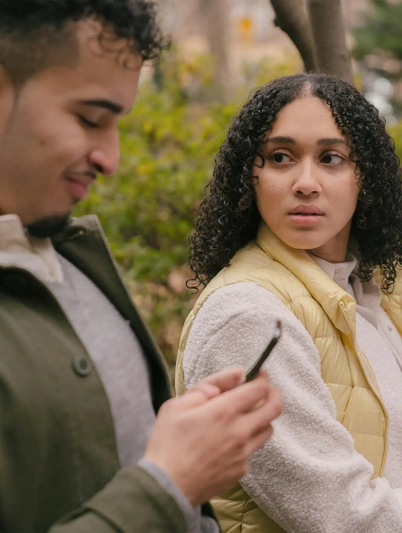 Pareja discutiendo en un parque, cómo controlar los celos y la desconfianza en la pareja.