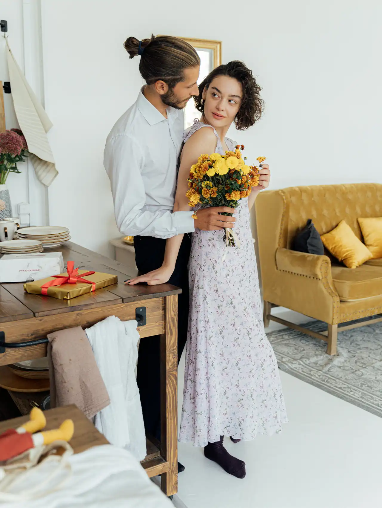Hombre entregando flores a su pareja en casa – cómo mejorar la relación de pareja con detalles románticos.