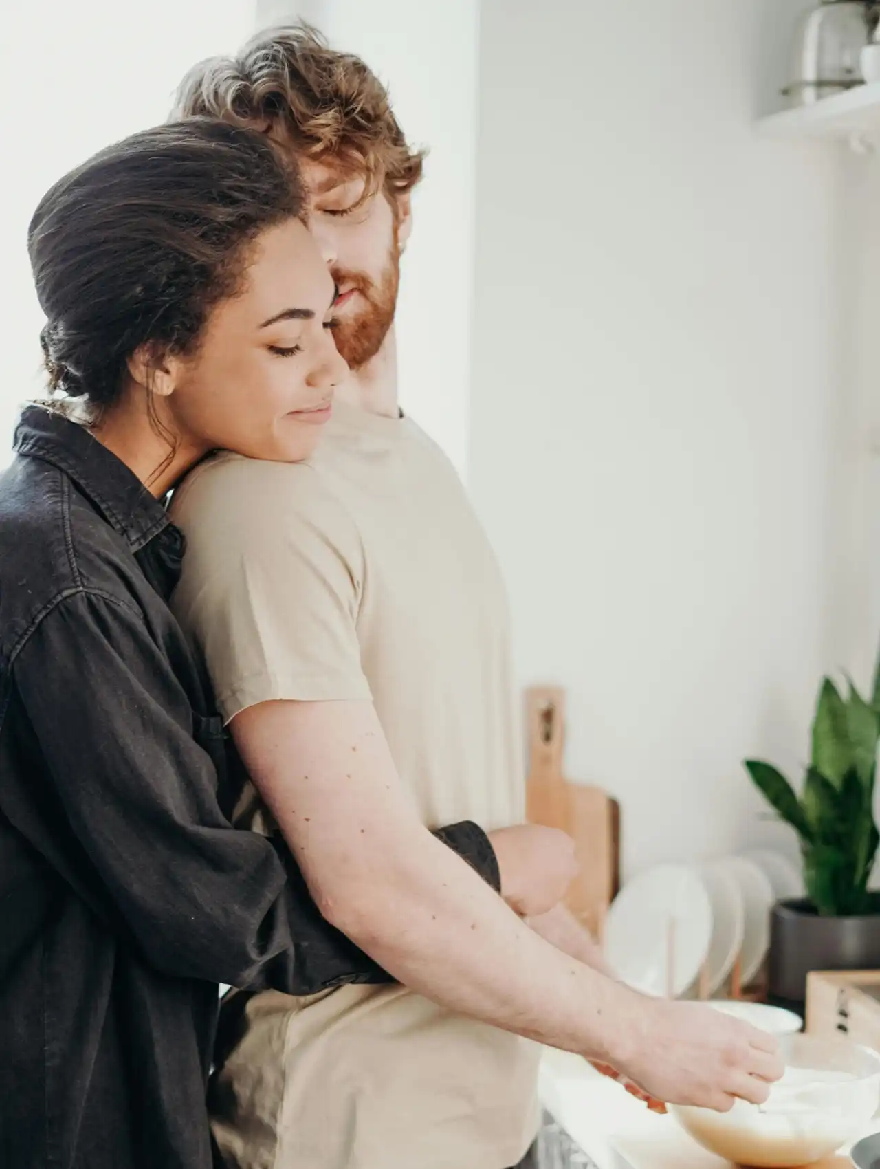 Pareja abrazándose en la cocina mostrando contacto físico, cuáles son los lenguajes del amor.
