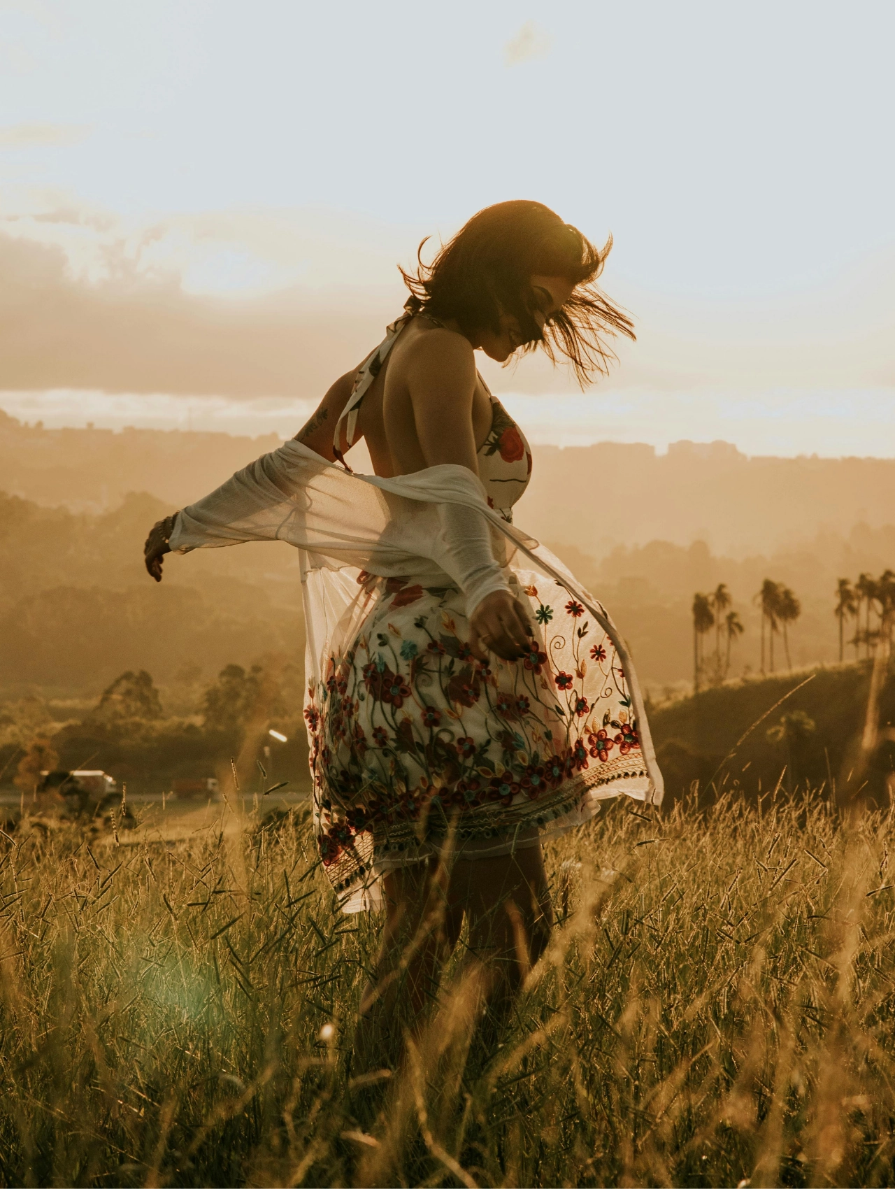 Mujer bailando al atardecer, cómo superar una ruptura amorosa.