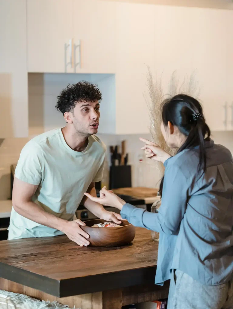 Pareja discutiendo en la cocina, reflejando tensiones en las relaciones amorosas.