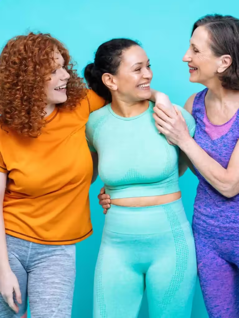 Tres mujeres de distintas edades y estilos disfrutando juntas después de hacer ejercicio, representando diversidad corporal y cómo elegir según tu caso cuáles son las mejores pastillas anticonceptivas