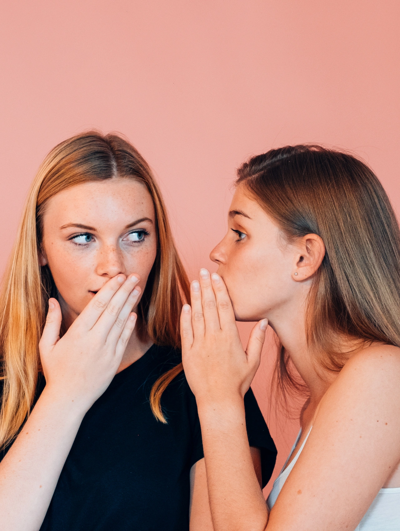 Dos jóvenes conversando en secreto, representando los mitos y dudas más comunes sobre si las pastillas anticonceptivas son seguras.