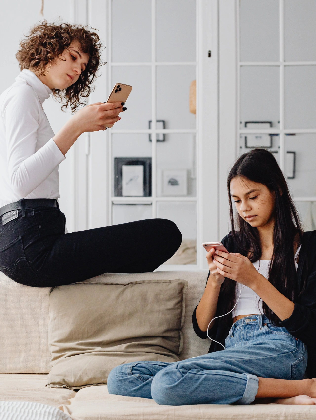Dos mujeres revisando sus teléfonos en un ambiente relajado, representando la búsqueda de información confiable sobre si las pastillas anticonceptivas son seguras