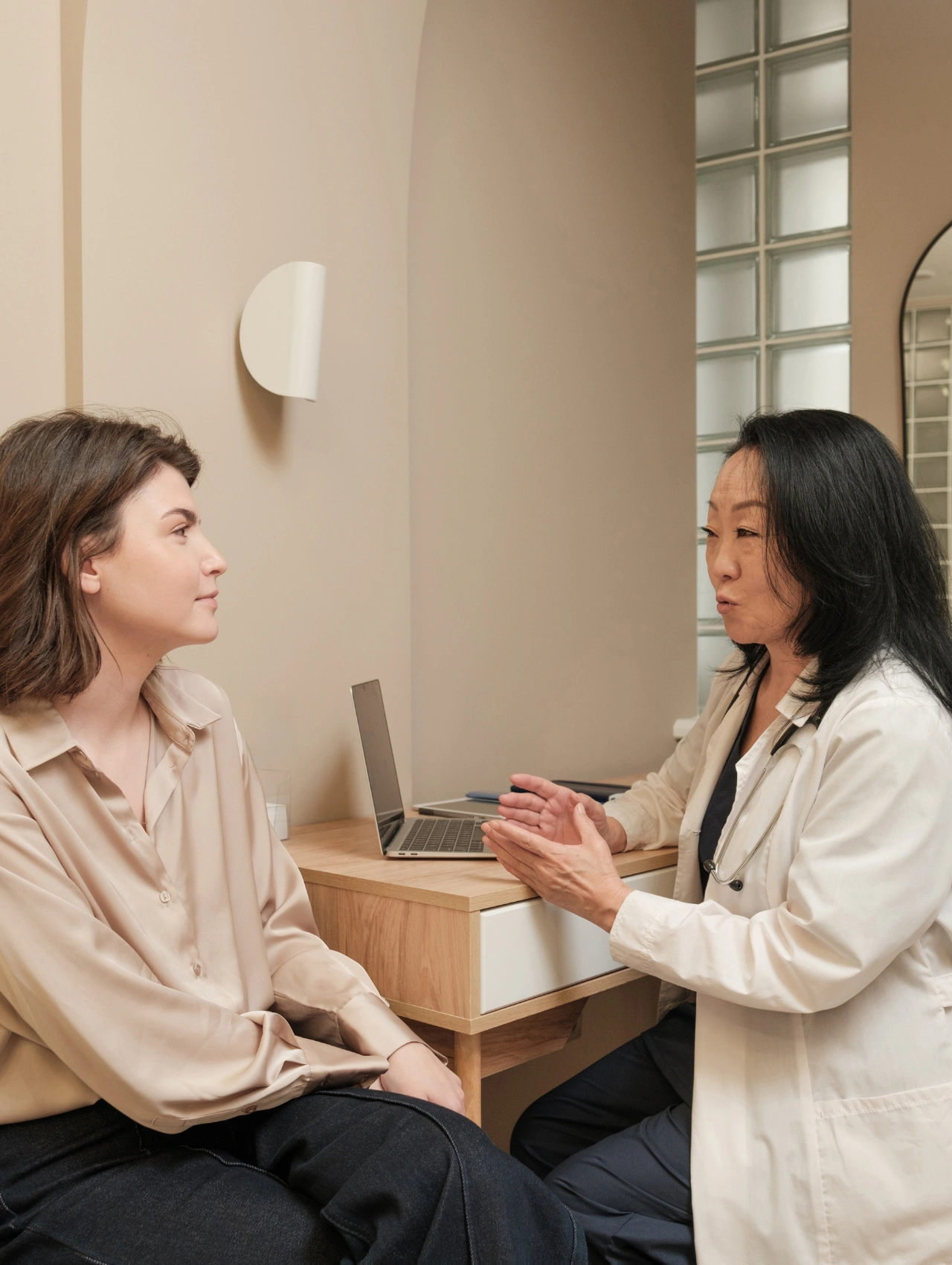 Mujer conversando con su doctora en una consulta privada, enfocada en resolver preguntas sobre los métodos anticonceptivos