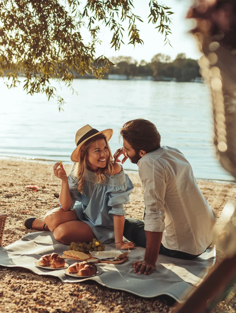 Pareja disfrutando un picnic romántico a la orilla de un lago, ejemplo inspirador de un picnic romántico, picnic romantico, para artículo: Así se planea un picnic romántico digno de Instagram en 5 pasos simples