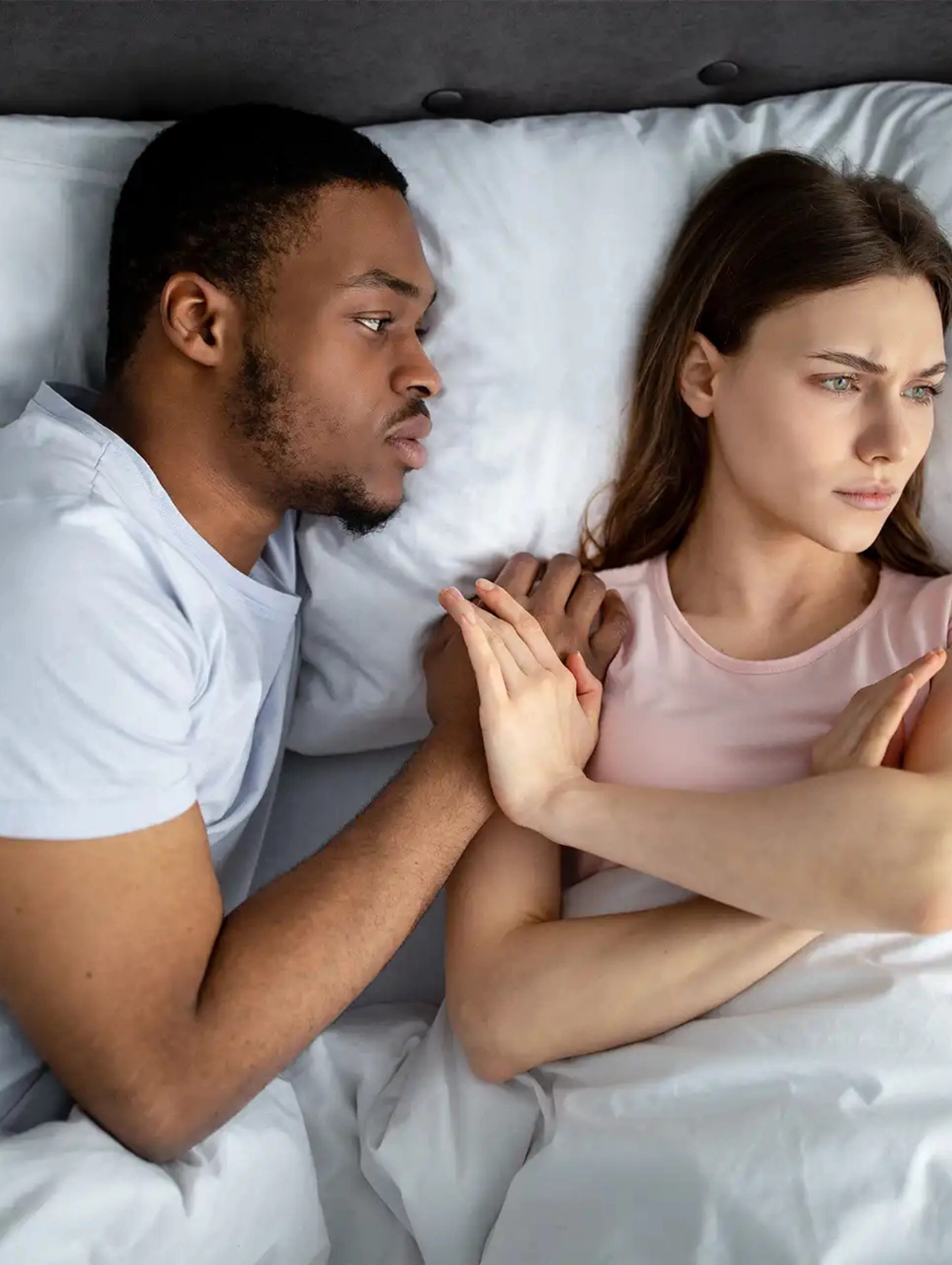 Pareja en la cama mostrando tensión emocional como posible señales de intimidad e infidelidad, señales de infidelidad de una mujer, mirada evasiva y lenguaje corporal distante