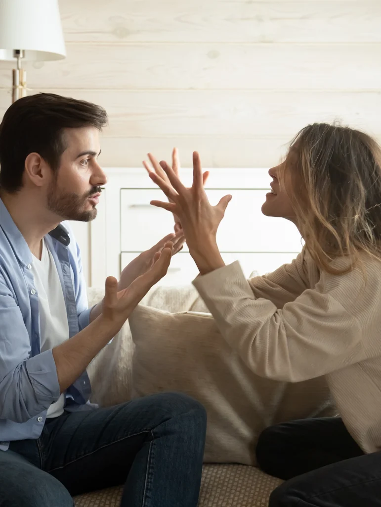Pareja discutiendo en el sofá: representación visual de red flags en mujeres, celos, confrontación emocional y tensión en la comunicación, para artículo 10 red flags en mujeres que todo hombre debería reconocer antes de enamorarse