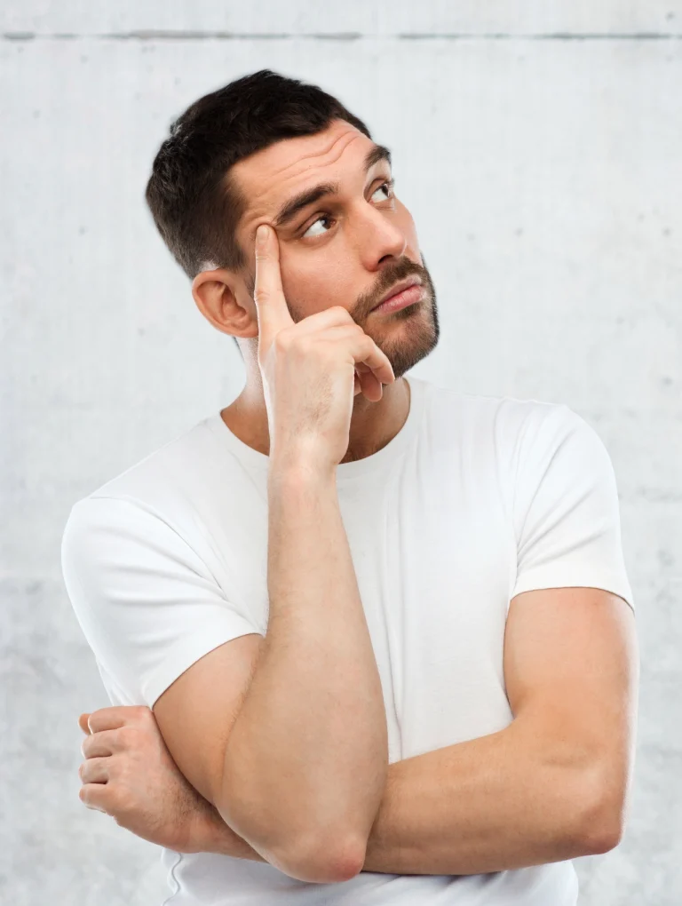 Hombre pensativo con la mano en el rostro, representando la duda y la reflexión al buscar cuáles son los condones más seguros cuando también se prioriza el placer y la confianza en pareja.