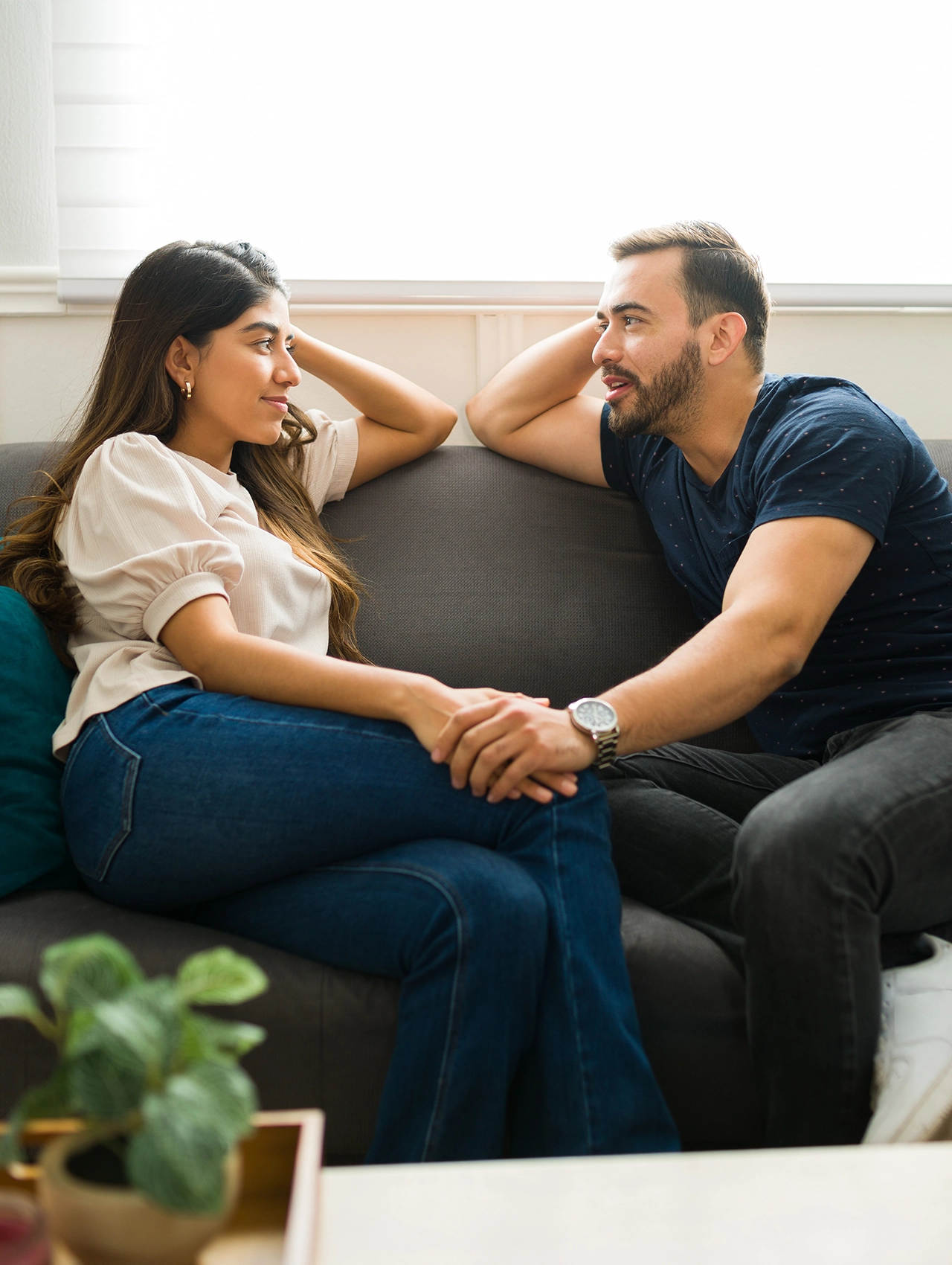 Pareja conversando en el sofá demostrando cómo aprender a escuchar activamente y fortalecer la conexión emocional en una relación.