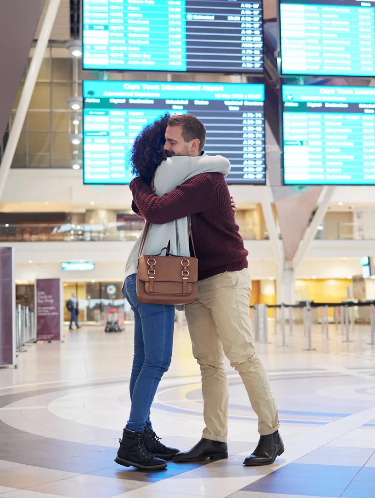 Pareja abrazándose en aeropuerto mostrando cómo llevar una relación a distancia con conexión emocional y reencuentros significativos
