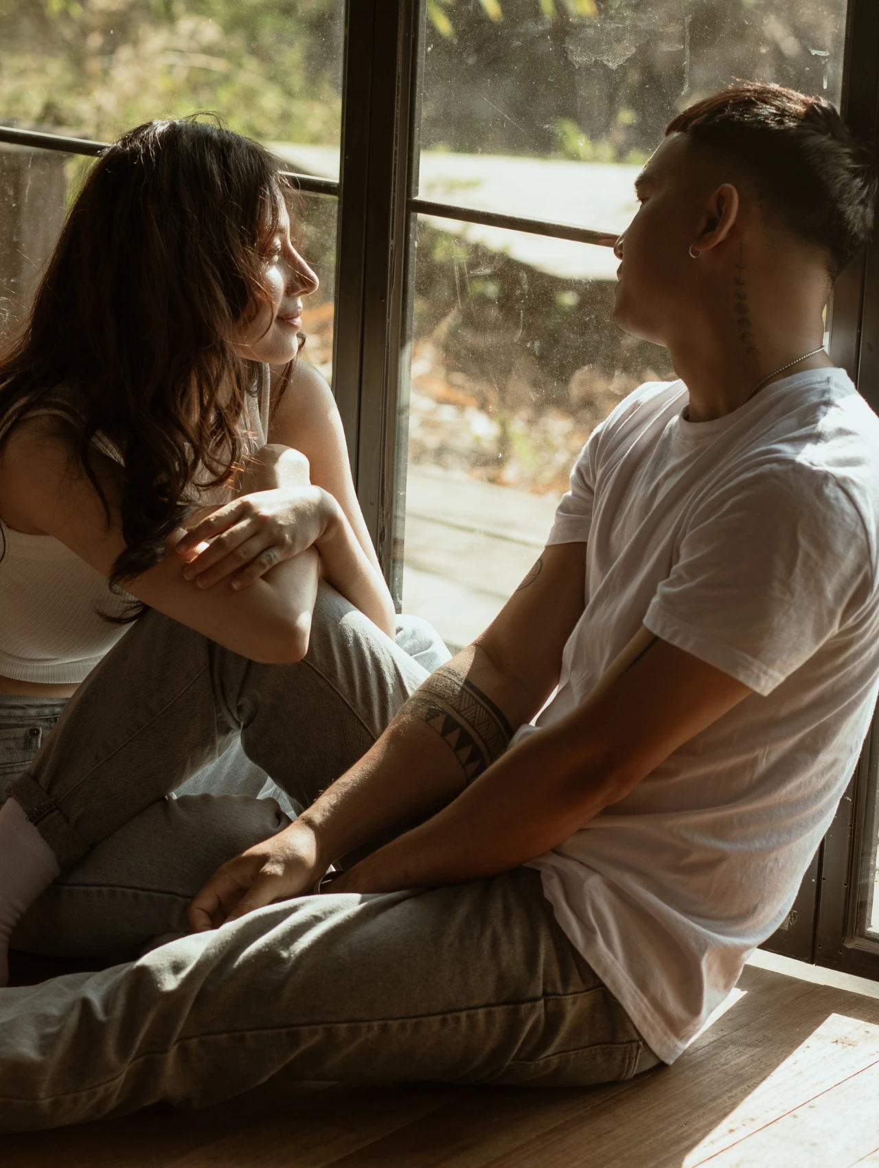 conversaciones-dificiles-claves-para-afrontarlas-con-mas-seguridad-emocional Pareja sentada junto a una ventana en un momento de escucha y cercanía, imagen ideal para ilustrar conversaciones difíciles y claves para afrontarlas con más seguridad emocional.
